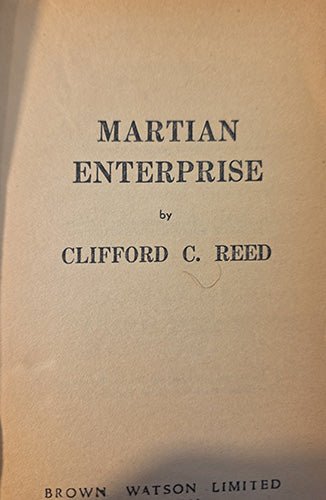 A close-up of a vintage book cover or title page with the title 'MARTIAN ENTERPRISE' and author 'CLIFFORD C. REED' printed in dark blue text on aged beige paper.