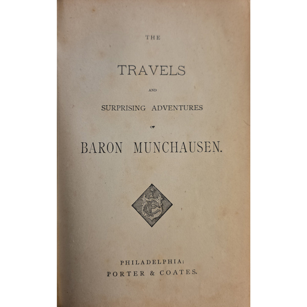 A vintage book cover titled 'The Travels and Surprising Adventures of Baron Munchausen' with black serif text on aged tan paper and a small diamond-shaped crest near the center.