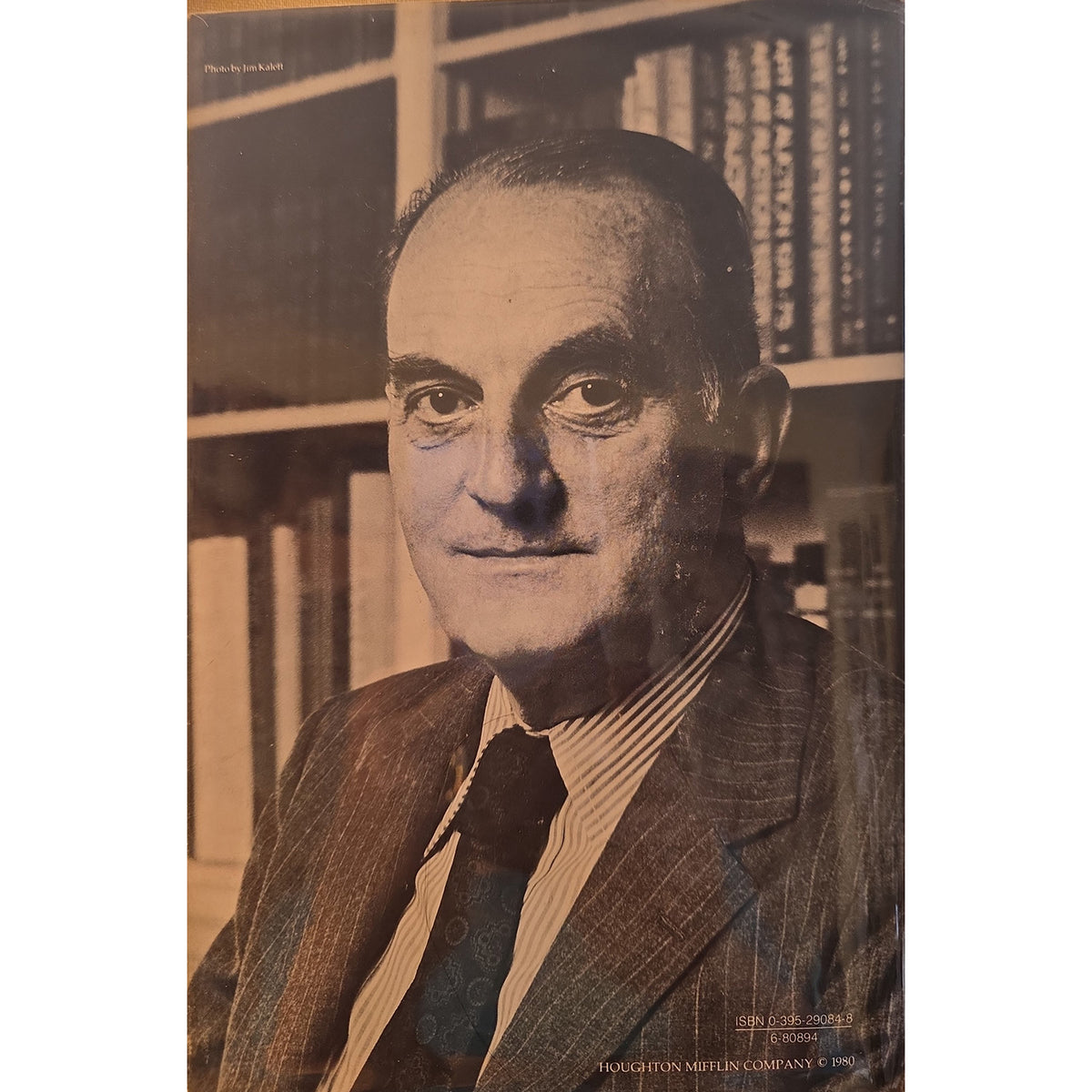Back cover of a book with A vintage portrait print of a man in a pinstripe suit and tie, posed in front of bookshelves. The print has a sepia-toned color palette with text at the top and bottom.