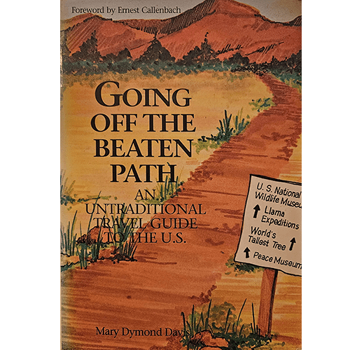 Cover of "Going Off the Beaten Path" by Mary Dymond Davis features a scenic dirt path flanked by greenery and mountains, with signs highlighting quirky U.S. destinations, evoking an adventurous spirit.