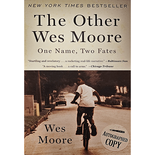 The cover of The Other Wes Moore: One Name, Two Fates by Wes Moore shows a young boy biking away on a residential street. It features praise from critics and an "Autographed Copy" seal.