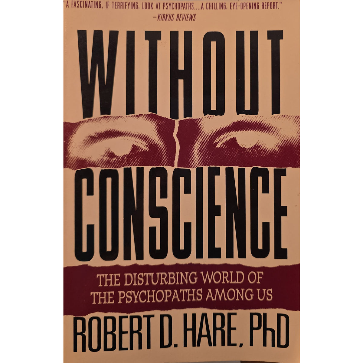 Book cover of 'Without Conscience' by Robert D. Hare, PhD, featuring a tan background with bold black title text, torn dark red eye imagery across the center, and a dark red subtitle band.