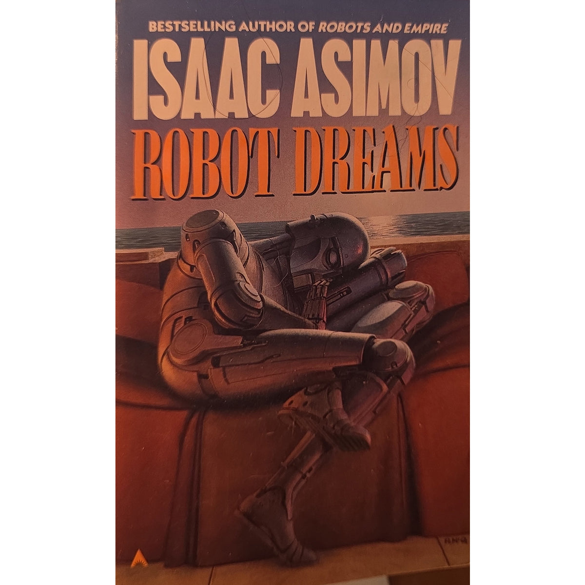 Book cover of Isaac Asimov's 'Robot Dreams' featuring a robot curled up on a reddish-brown platform against a dark sky, with the title in large orange letters.