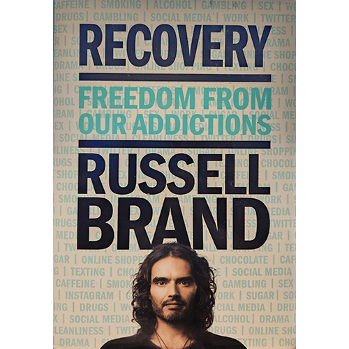 Cover of "Recovery: Freedom from Our Addictions" by Russell Brand, featuring a background with various addiction-related words and a photo of the author at the bottom, with bold blue and teal text.