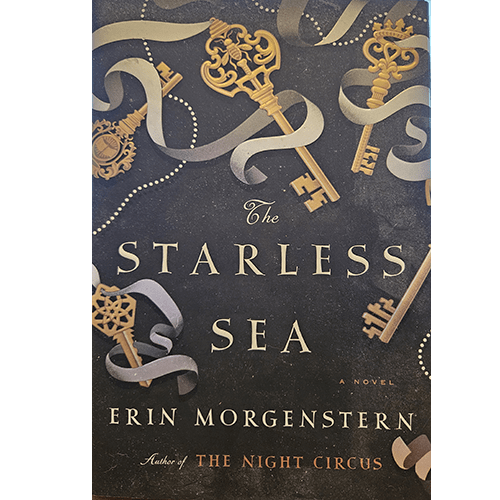 The cover of "The Starless Sea" features intricate golden keys and swirling ribbons set against a dark, starry background, evoking a sense of mystery and fantasy. The title and author’s name are centered in elegant text.