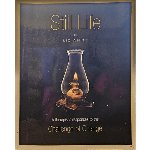 The cover of Still Life by Liz White features a serene oil lamp flame within a glass container against a dark, calming background. Subtitled, "A therapist's responses to the Challenge of Change," it conveys introspection.