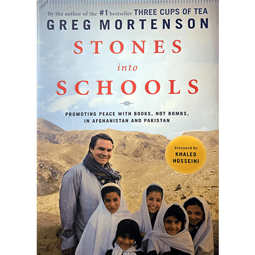 Cover of Stones into Schools by Greg Mortenson, showing the author with smiling children in Afghanistan against a mountain backdrop.