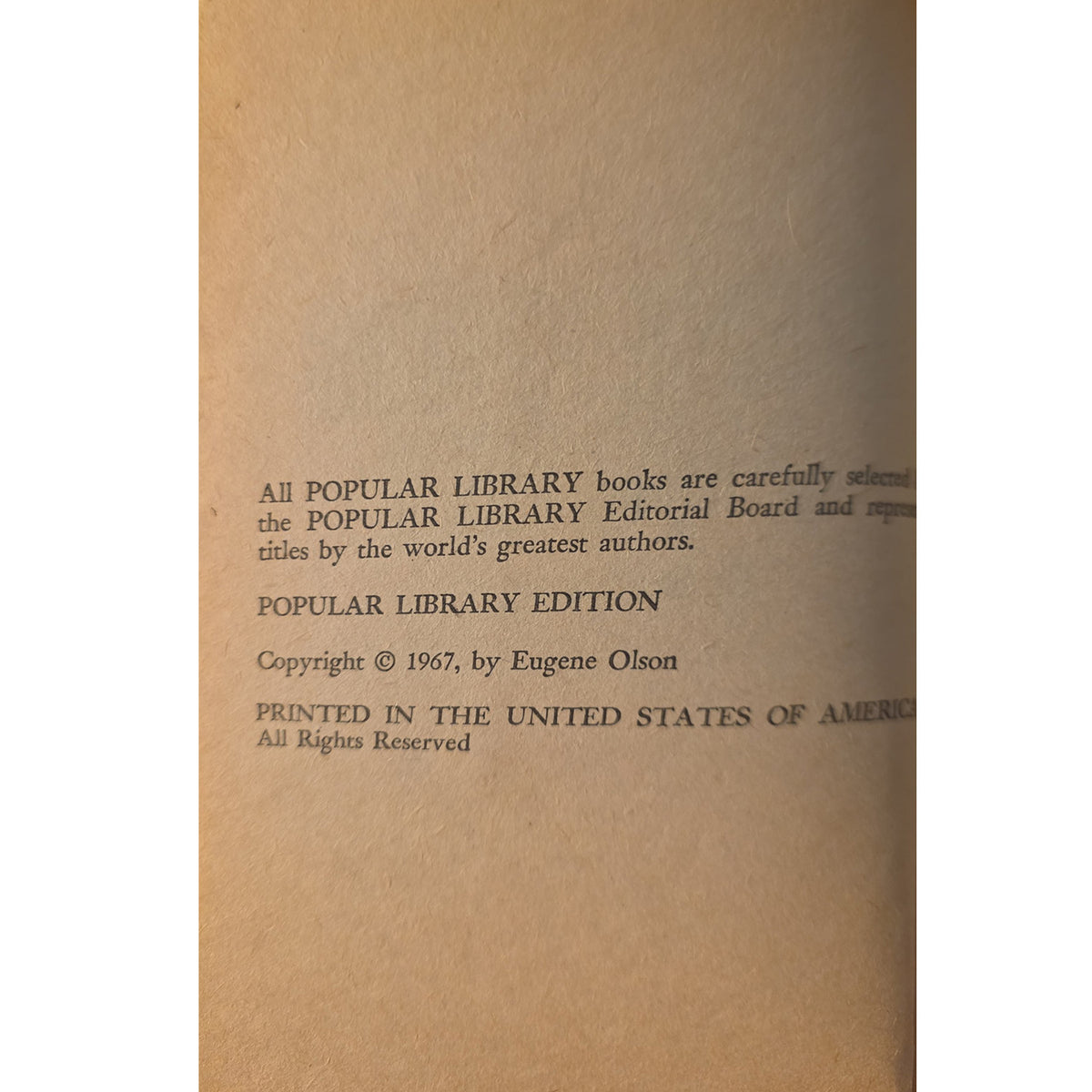A vintage book page with black printed text on tan paper, reading 'Popular Library Edition' and 'Copyright © 1967, by Eugene Olson'.