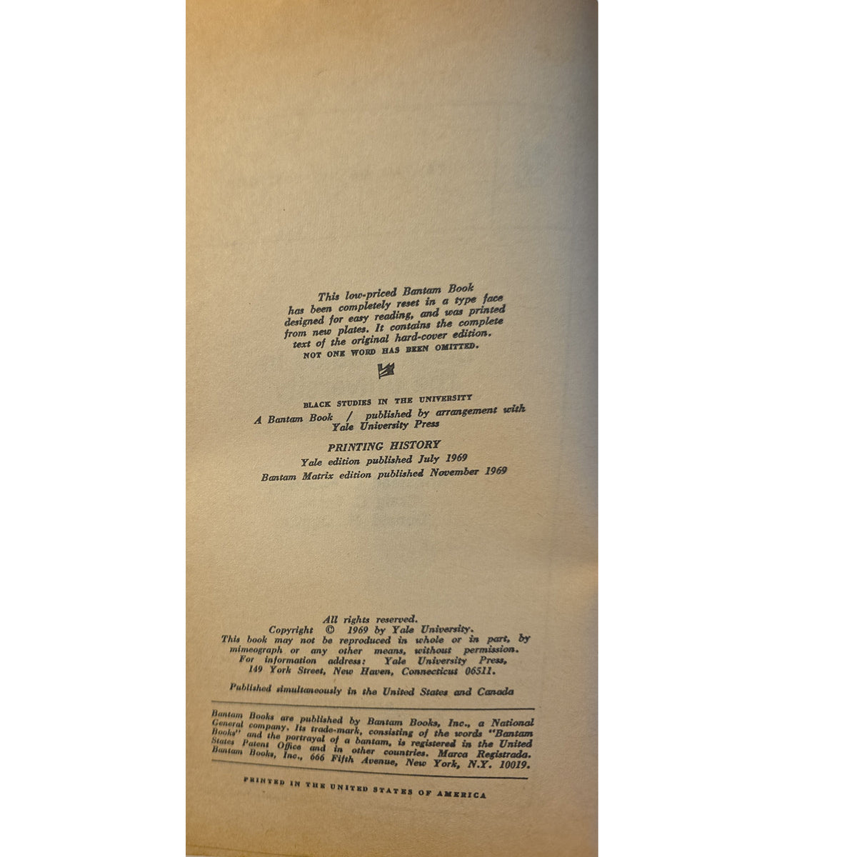 A close-up of the interior back cover of a vintage paper book, showing printed copyright and publisher text on warm tan paper.