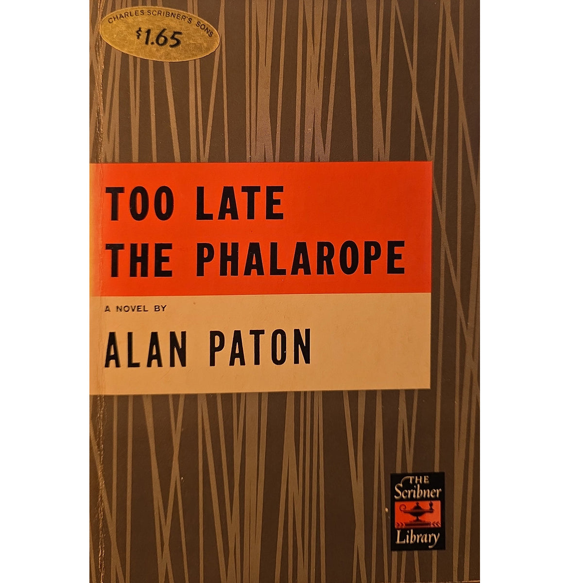 Vintage paperback book cover of 'Too Late the Phalarope' by Alan Paton, featuring a brown wood-grain pattern background with a prominent orange and beige title block and a gold price sticker at the top.