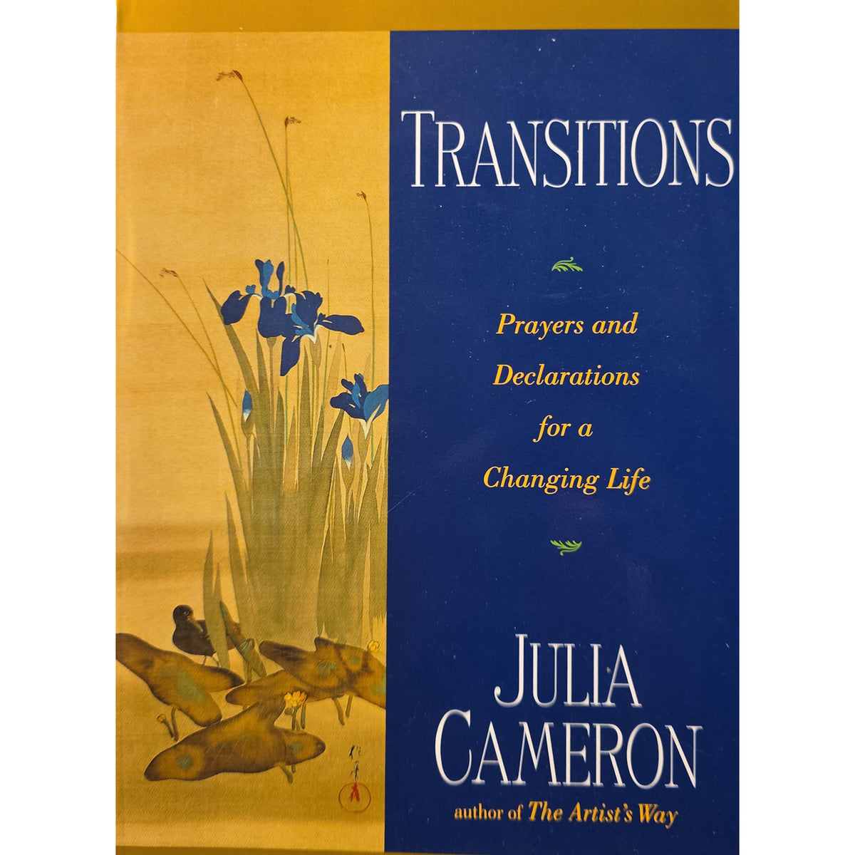 Book cover of 'Transitions: Prayers and Declarations for a Changing Life' by Julia Cameron, featuring a split design with a gold-toned left side showing blue irises and fish, and a dark blue right side with white and gold text.