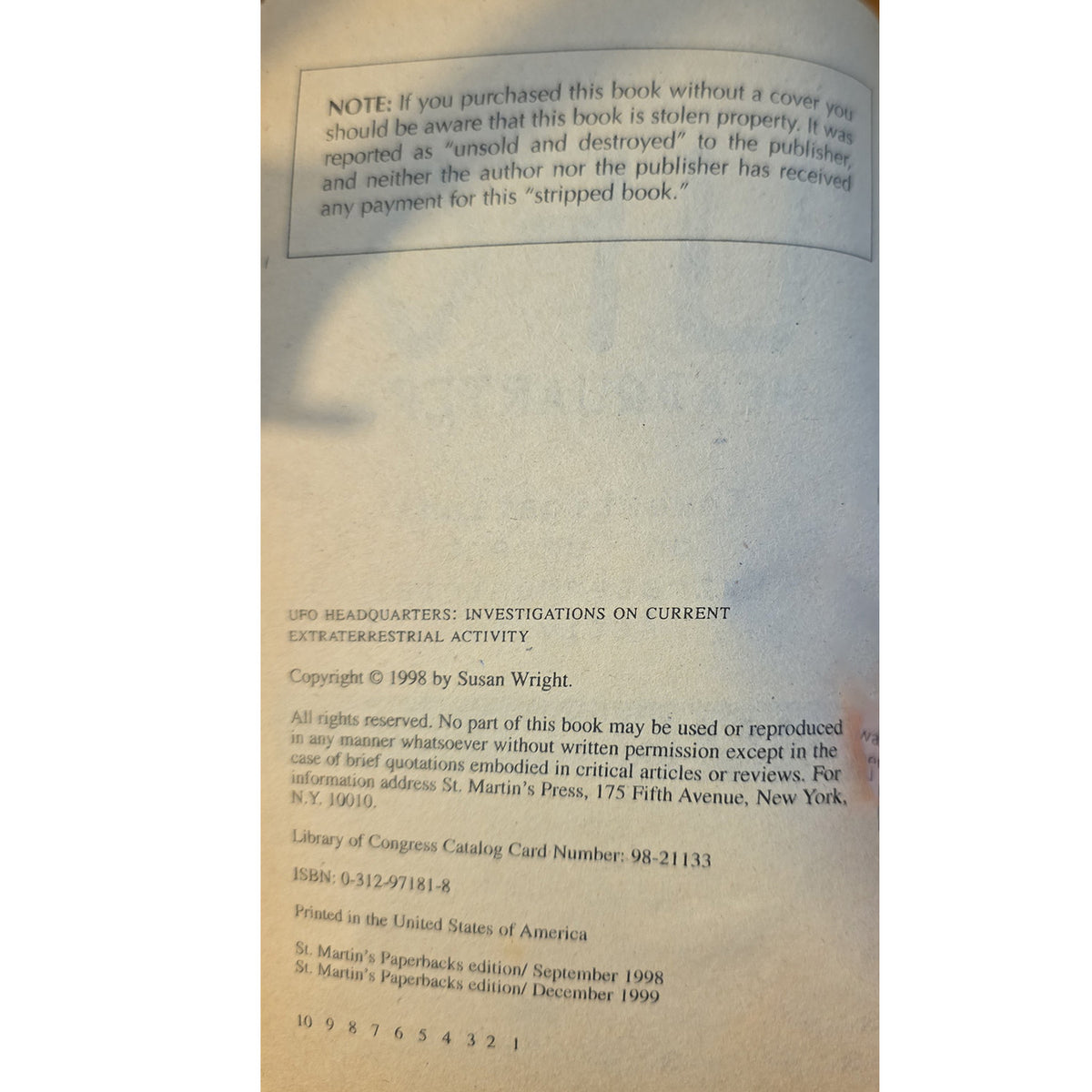 A close-up of a book's back cover showing copyright and publisher information printed in light blue ink on an off-white paper background.