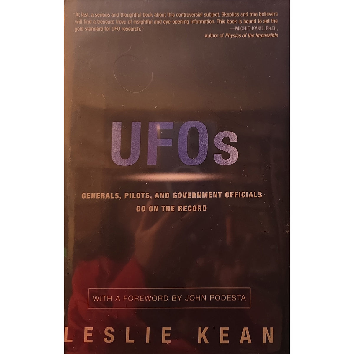 Book cover of 'UFOs' by Leslie Kean, featuring a dark brown background with purple 'UFOs' text and smaller white and gold text.